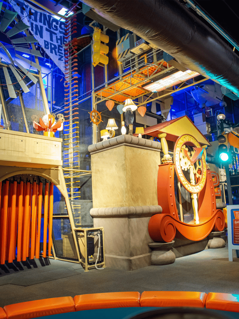 Colorful indoor playground with whimsical clock and playful structures for children's entertainment.