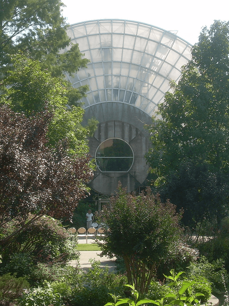 Futuristic greenhouse with lush greenery and modern glass architecture.