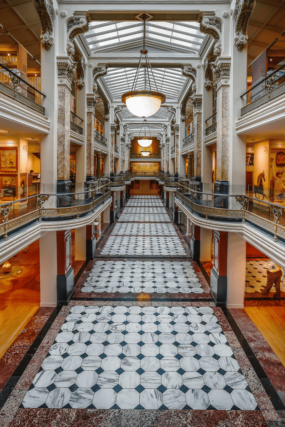 Intricate hotel lobby with classic architectural design, grand chandeliers, and marble flooring.