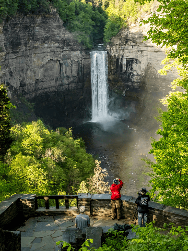 Waterfall view from observation deck with visitors capturing the scenic beauty.
