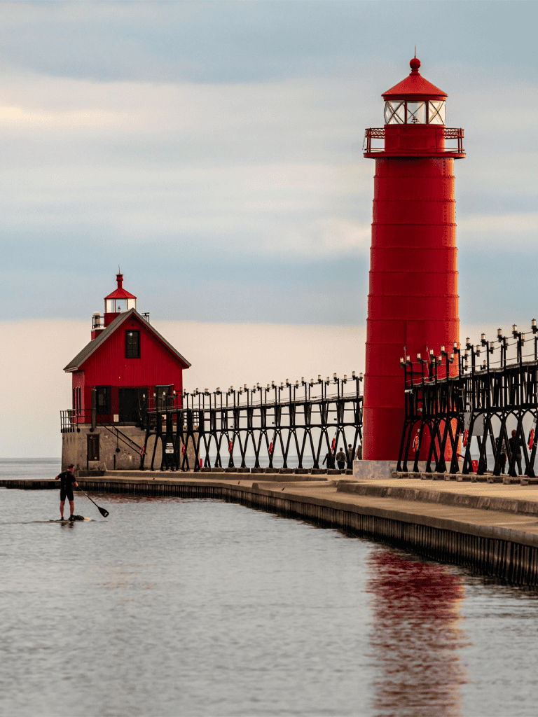 Colorful lighthouse on a pier at sunset, scenic coastal view for travel and navigation.