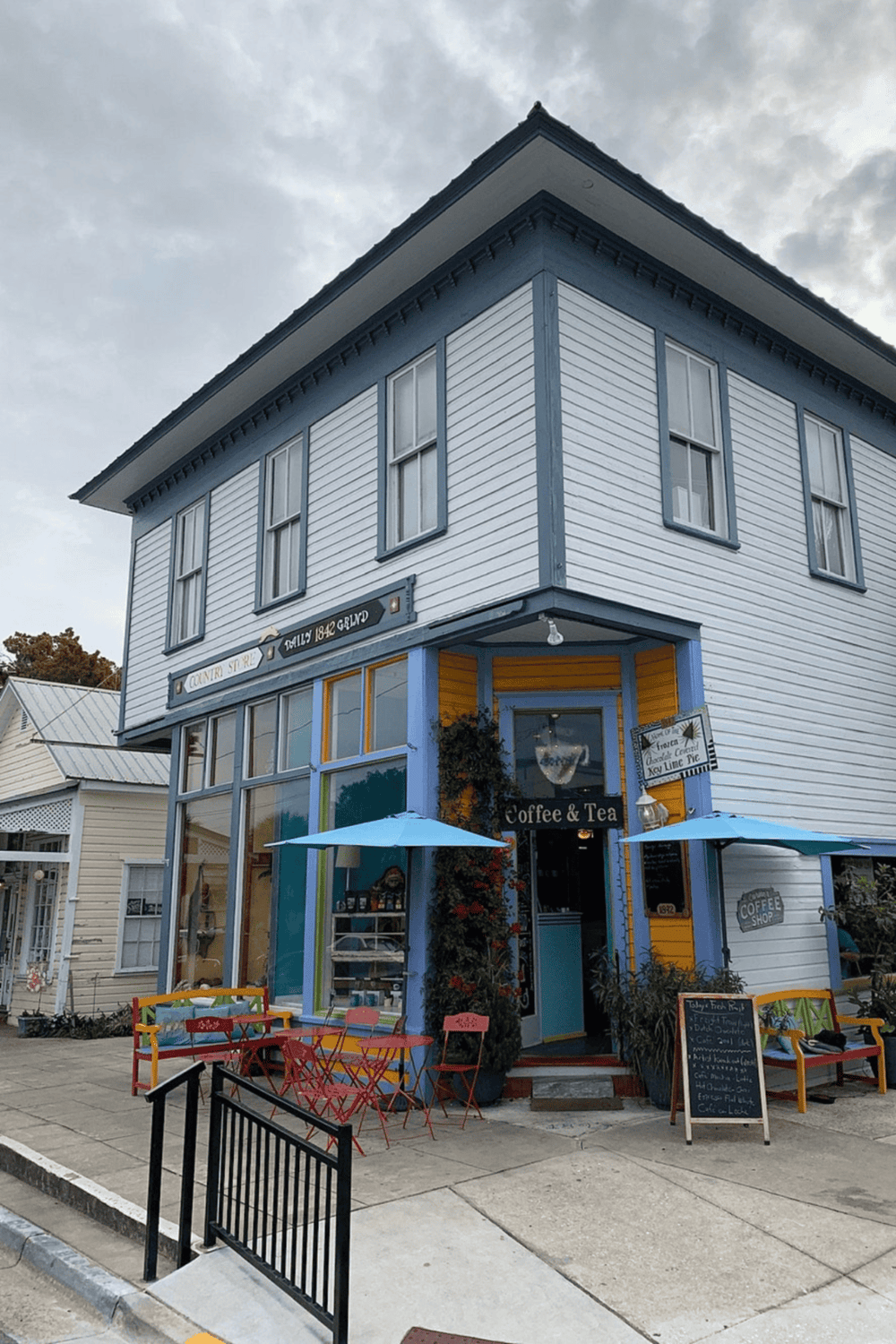 Cozy coffee shop in historic downtown with outdoor seating and colorful facade, perfect for local visits.