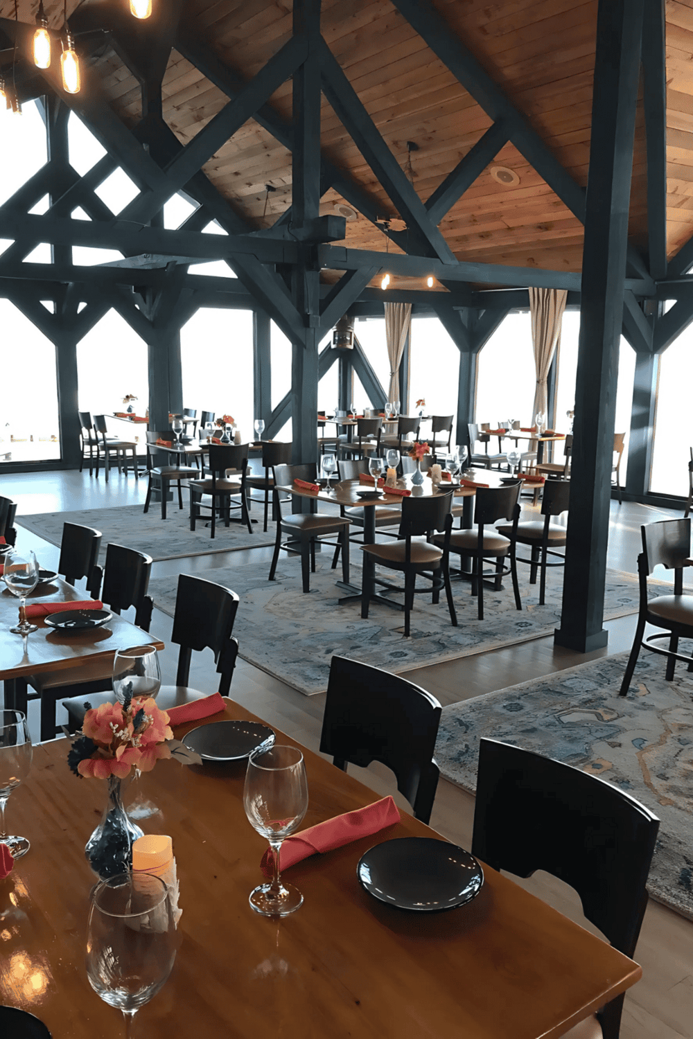 Cozy upscale restaurant with glass windows, wooden ceiling, modern interior decor, perfect for fine dining and special occasions.