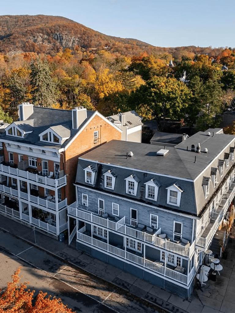 Cozy mountain town buildings in fall with colorful foliage background.