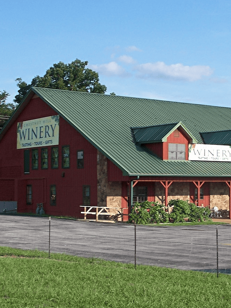 Vineyard winery building with red barn style architecture and green roof, near Quest for Directions.