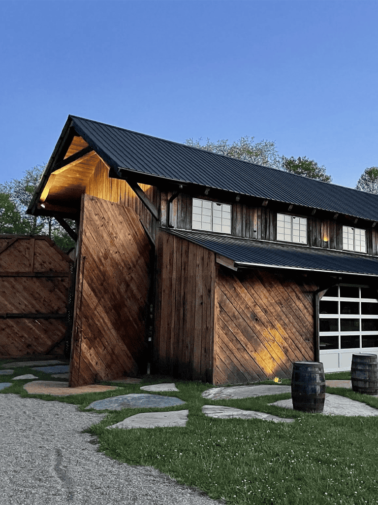Rustic barn exterior with wooden siding and black metal roof, perfect for countryside retreats.