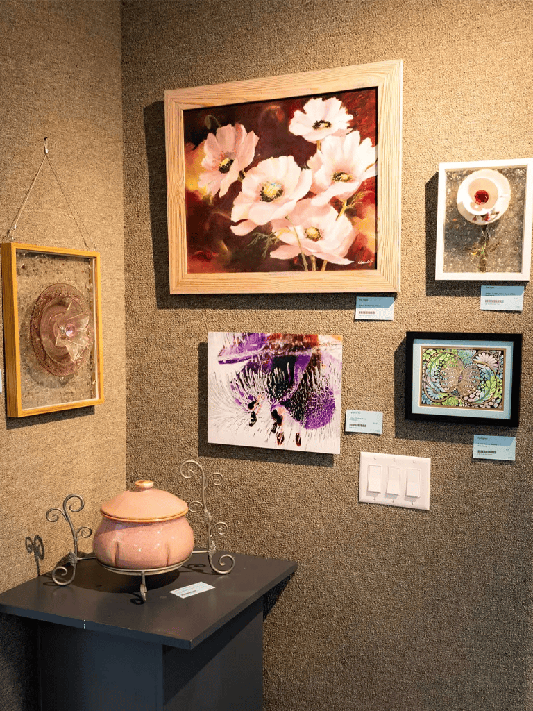 1. Elegant artistic gallery display of floral and abstract paintings and sculptures.