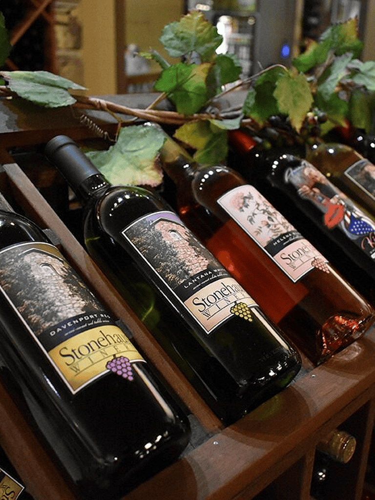 Elegant wine bottles from Stonehaven Winery displayed on a wooden rack, perfect for wine tasting and exploring local vineyards.