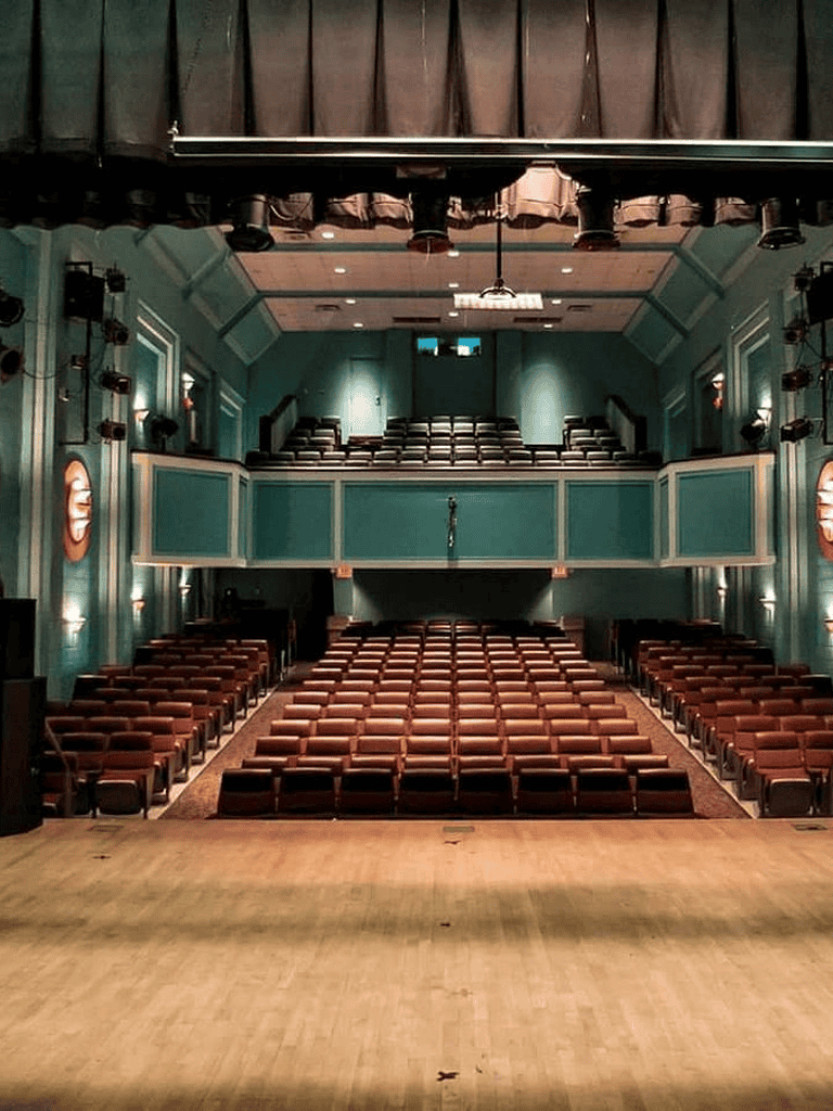 Comfortable theater seating with stage, perfect for performances and events.