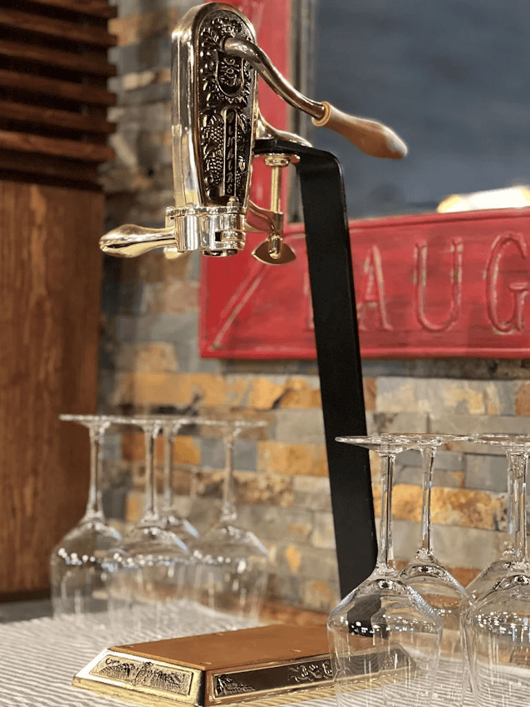 Vintage bar tap with wine glasses, ideal for cocktails and bar setups.