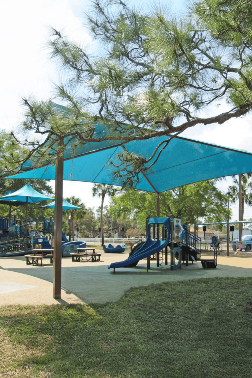 Colorful playground with slides and shade structures at QuestForDirections park, perfect for children's outdoor activities.