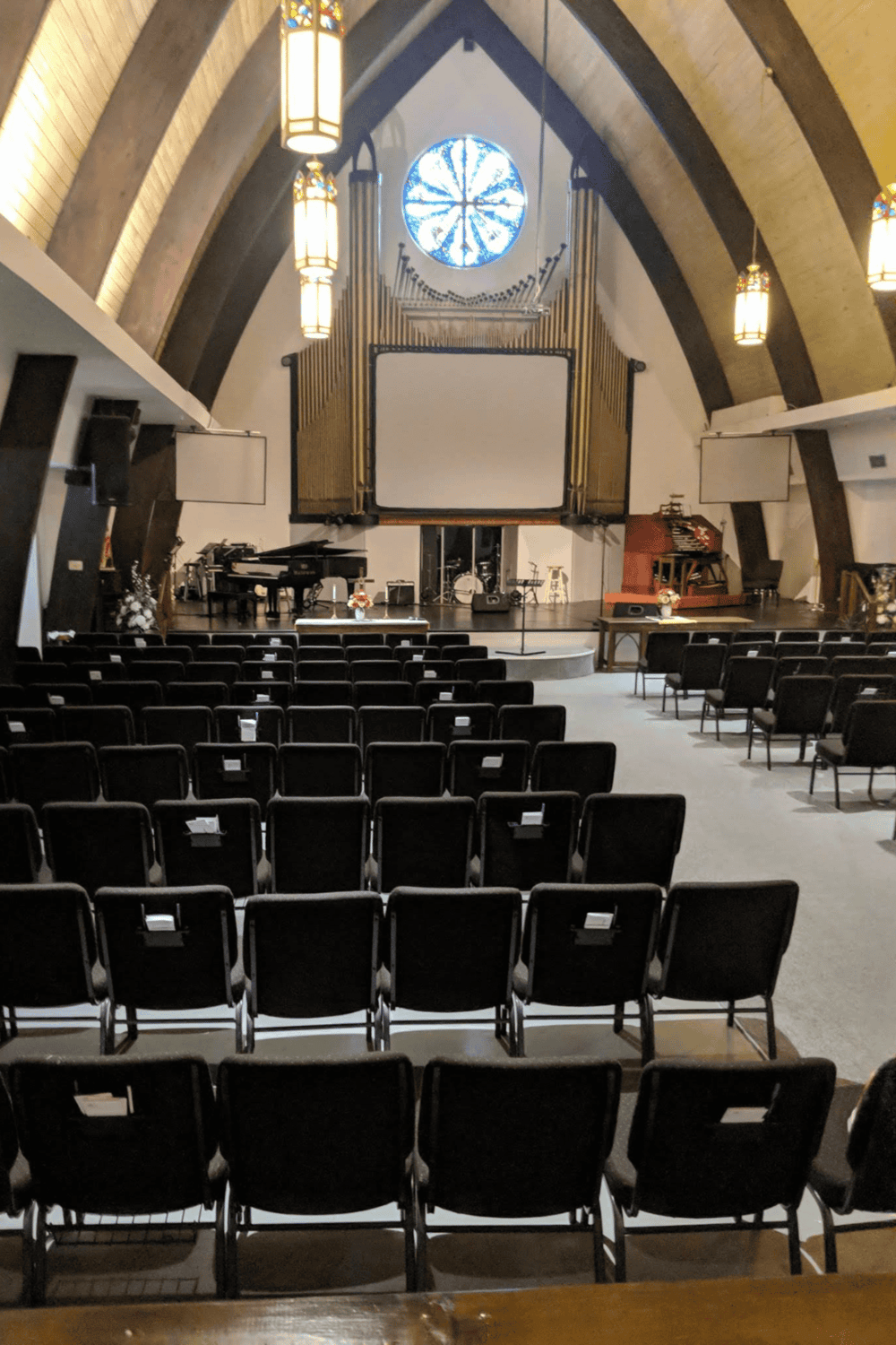 Church auditorium with stage, musical instruments, and large screen for events and worship.