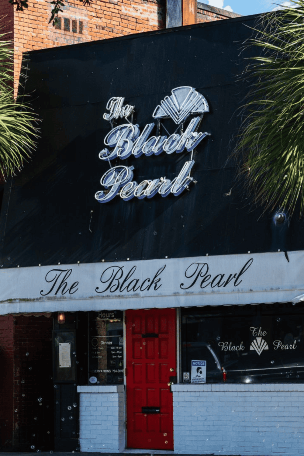 Elegant neon sign for The Black Pearl restaurant in a trendy downtown area.
