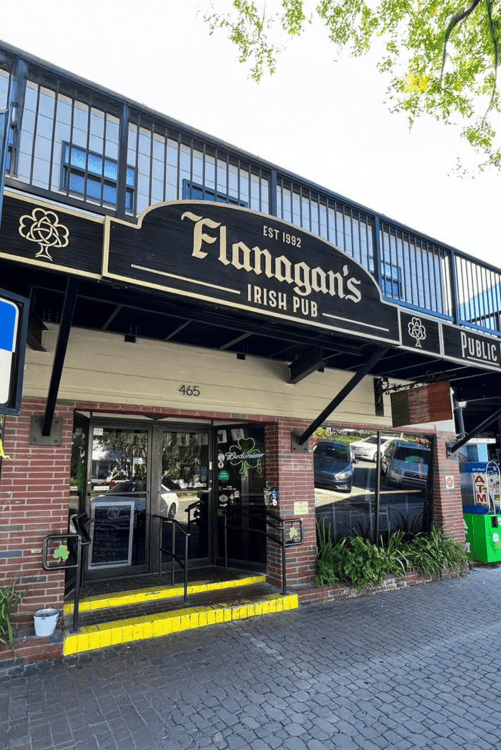 Irish pub entrance with "Flanagan's" sign, established in 1992, located at 465.