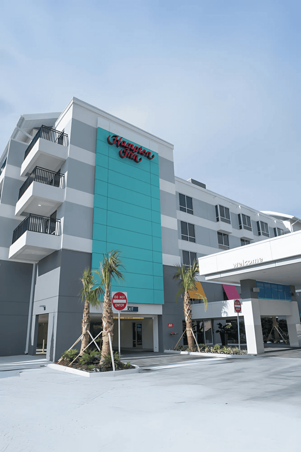 Modern Hampton Inn hotel exterior with balconies and welcoming entrance, perfect for travelers seeking comfortable accommodations.