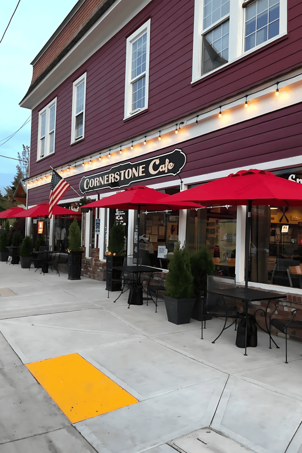 Freshly opened Cornerstone Café with outdoor seating and red umbrellas, ideal for a cozy dining experience.