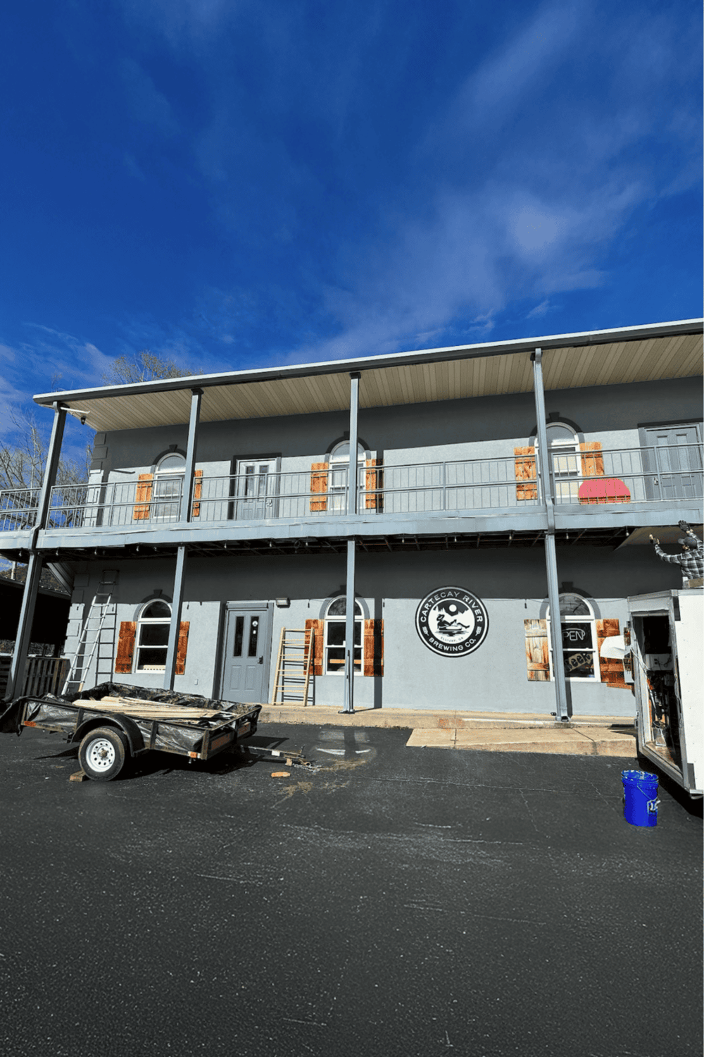 Modern brewery building with Cartecay River Brewing Co logo, under construction, on a clear day.