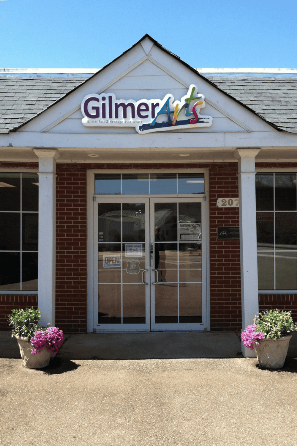 Colorful Gilmer Arts signage on building exterior with brick facade.
