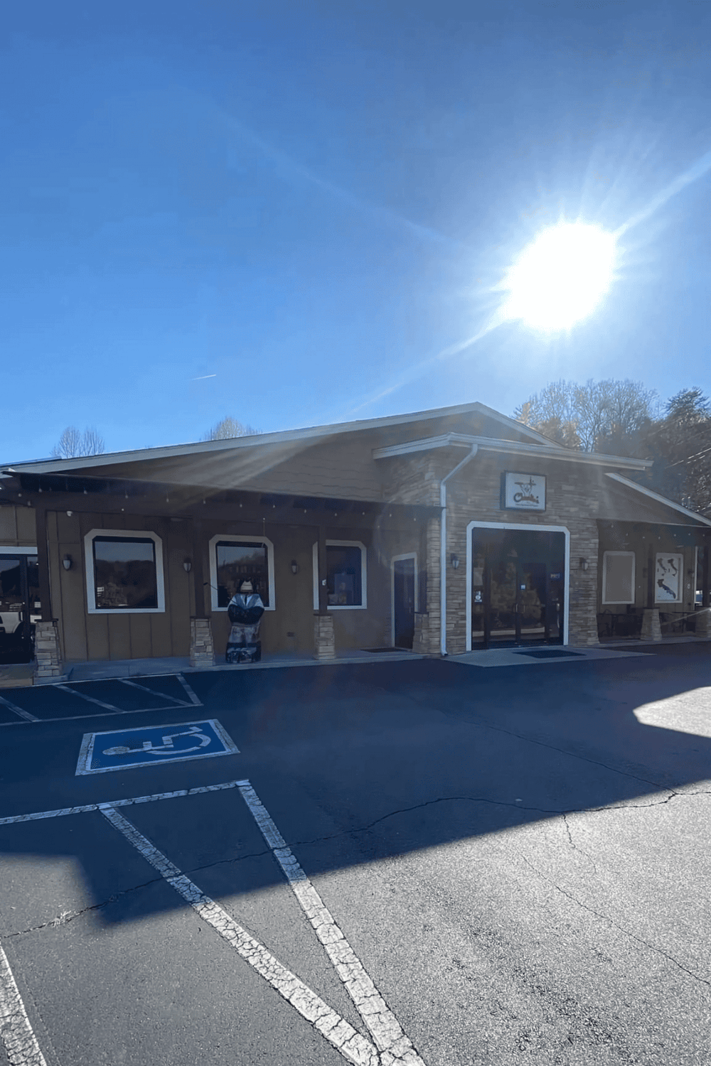 Handicap accessible parking lot outside Quest for Directions building on sunny day.