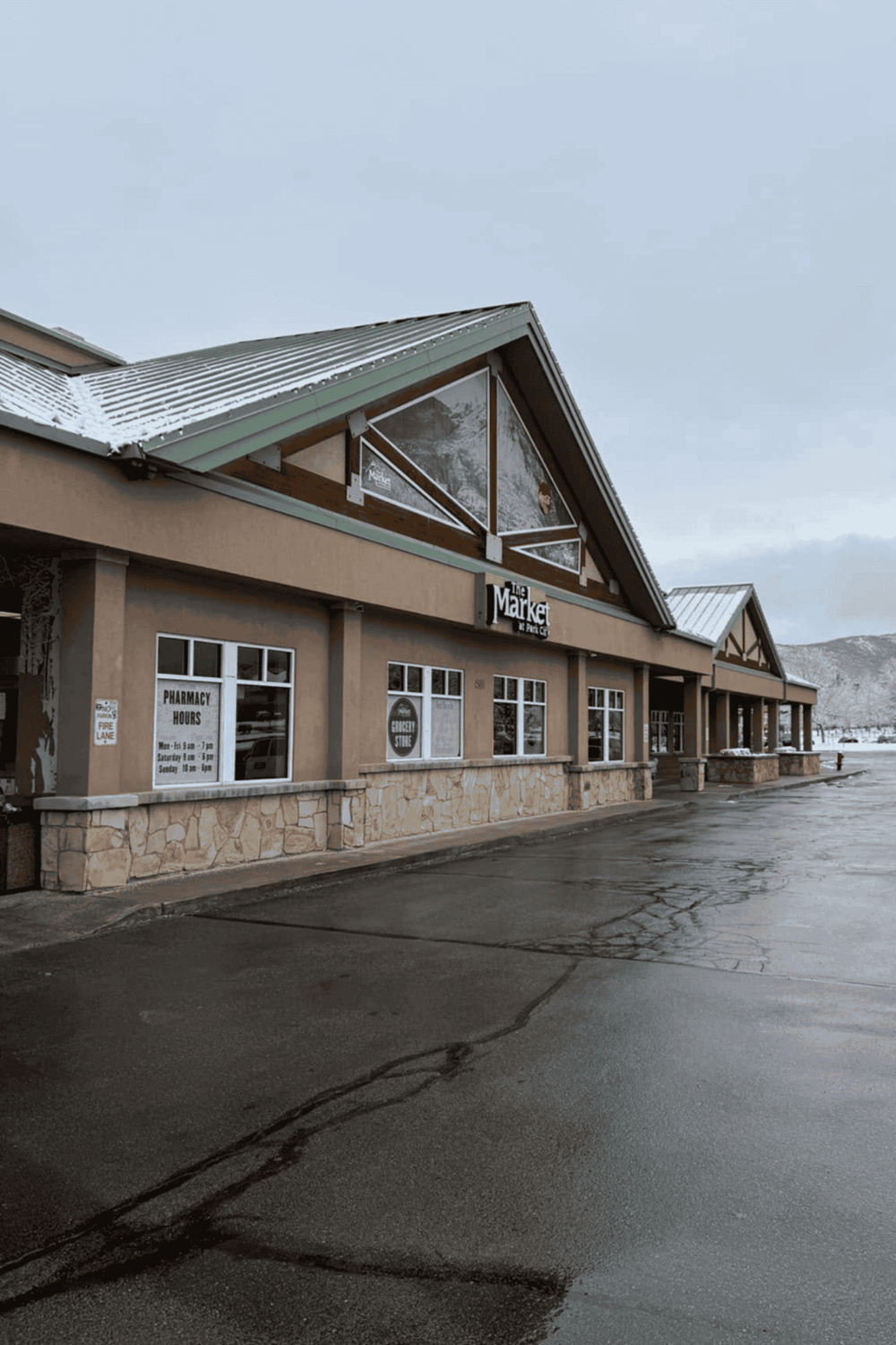 Clean grocery store exterior with mountain view, snow, and parking lot in Forest City.