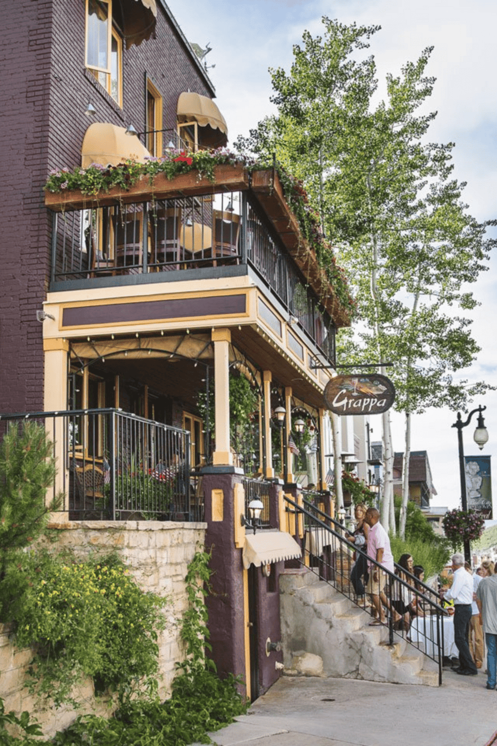 Cozy downtown restaurant with outdoor patio, ivy, and string lights for a charming dining experience.
