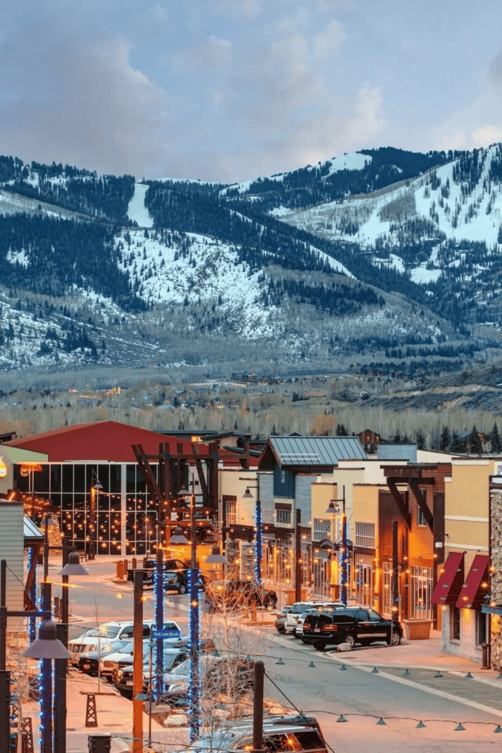 Winter mountain town with decorated streets and snowy slopes in the background, exploring travel destinations.