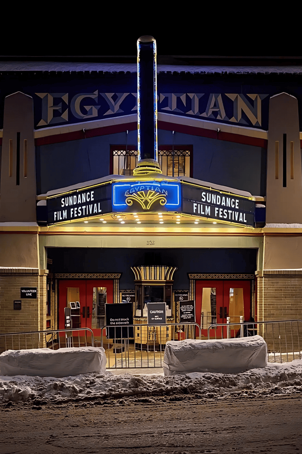 Egyptian Theatre marquee promoting Sundance Film Festival, nighttime illuminated landmark.