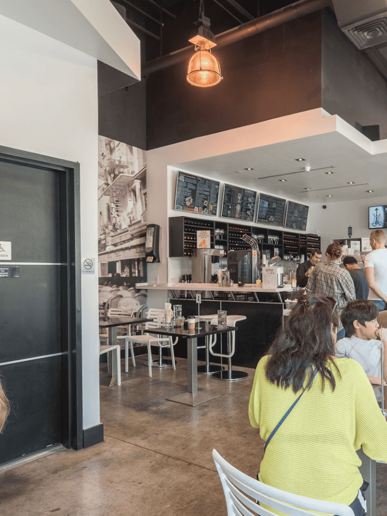 - Modern coffee shop interior with digital menu boards and seating area.