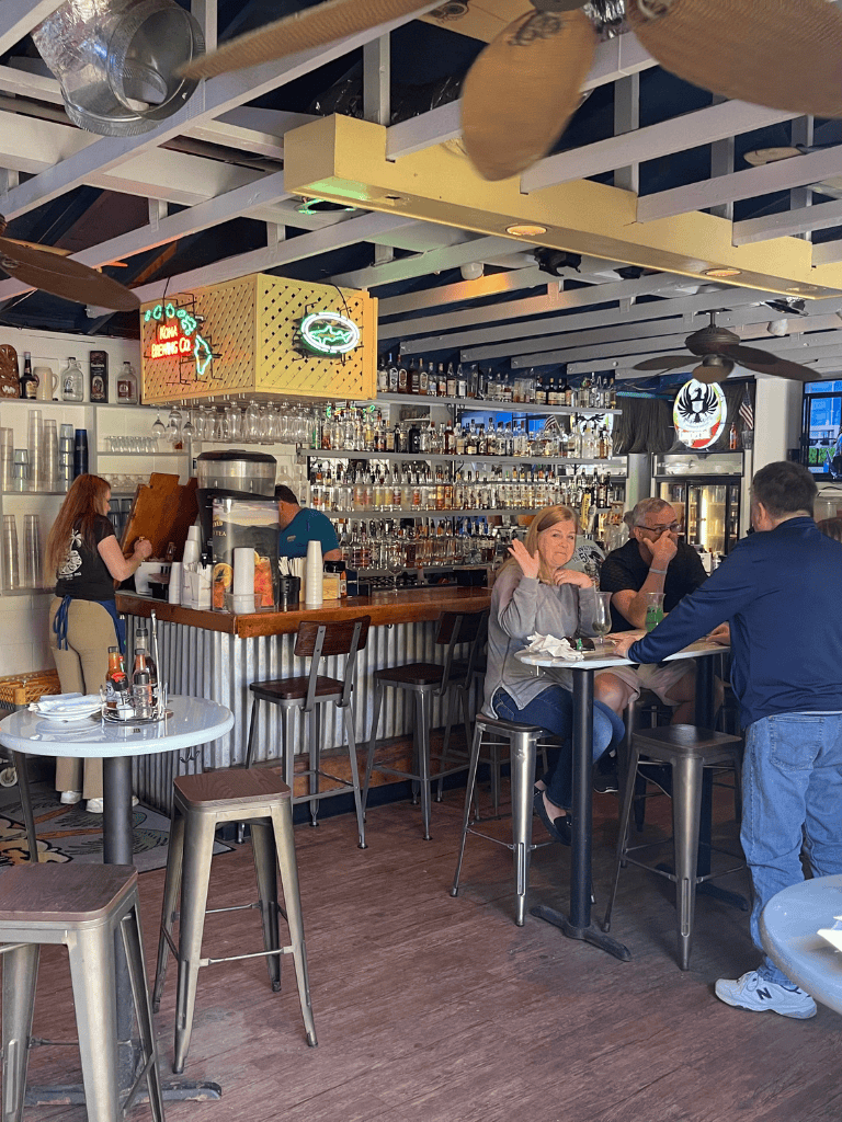 Cocktail bar at a modern restaurant with patrons enjoying drinks and friendly conversation indoor.