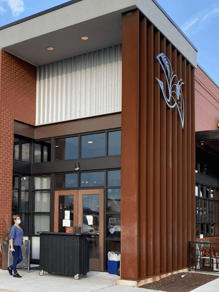 Modern QuestForDirections building featuring wood and brick design, inviting entrance, and friendly staff.