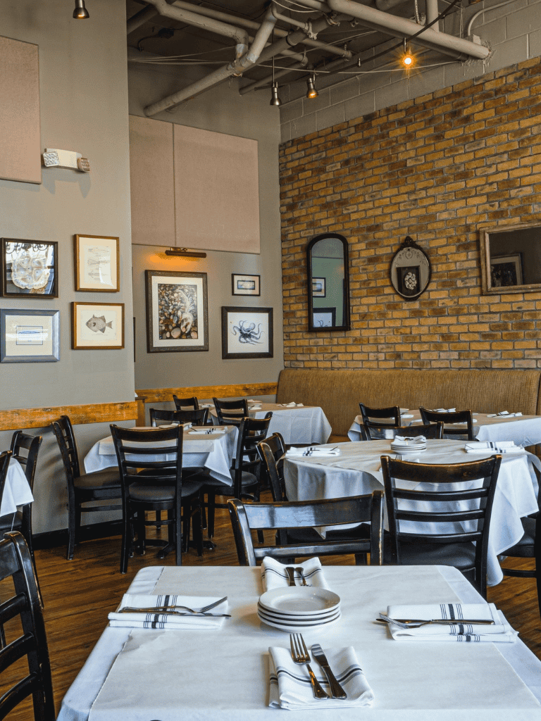 Cozy dining room with brick and wall art decor, perfect for intimate restaurant experiences.