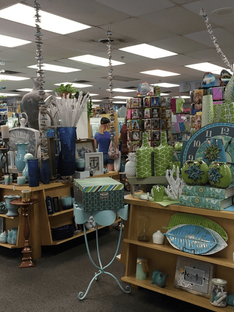 Vase and decorative home decor items in a store aisle, showcasing pottery, clocks, and giftware.