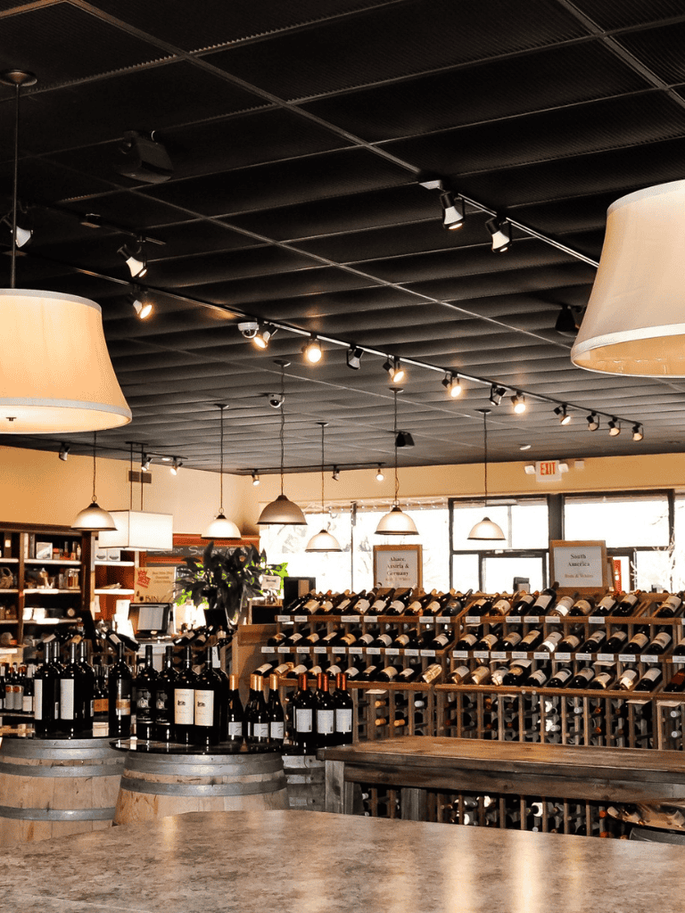 Elegant wine shop interior with floor-to-ceiling wine racks and cozy lighting for wine enthusiasts.