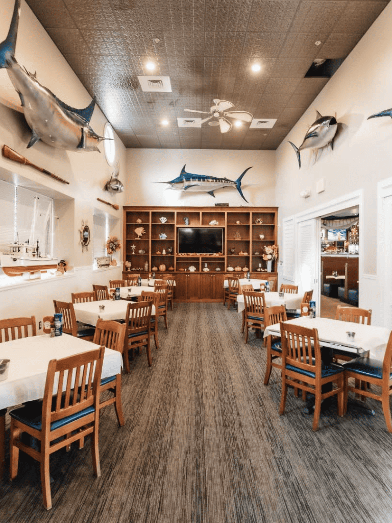 Colorful seafood restaurant interior with mounted fish decor, wooden tables, and marine-themed accents for a coastal dining experience.