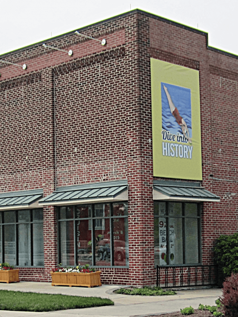 Historic brick building with "Dive into History" banner, part of Quest for Directions museum.