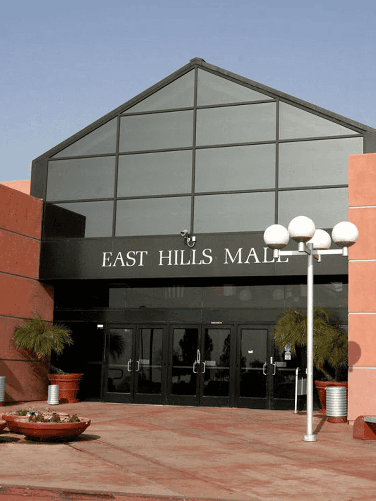 Modern shopping mall entrance with "East Hills Mall" signage and stylish exterior architecture.