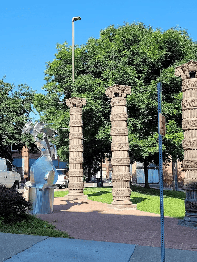 Stone ancient columns at QuestForDirections outdoor public space, historic architecture, cultural landmark, urban park, decorative pillars.