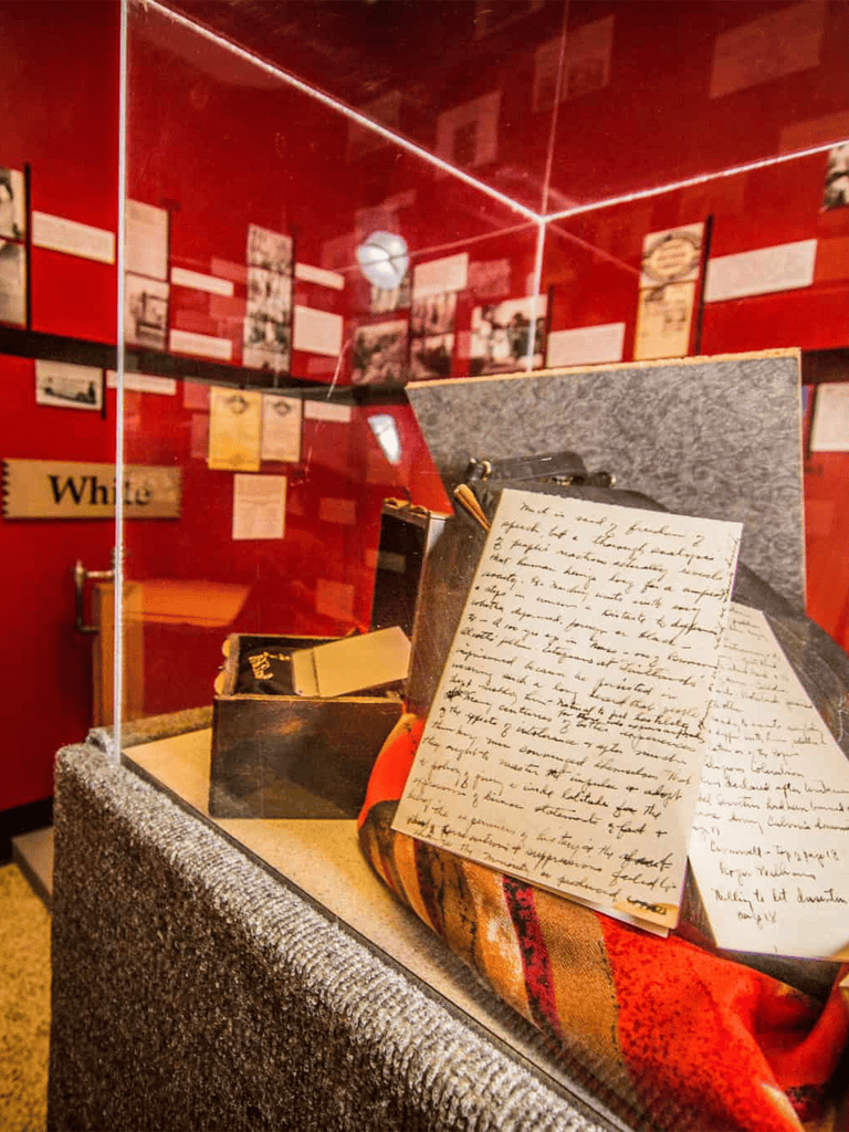 Historical handwritten letters displayed in a museum exhibit at Quest For Directions.