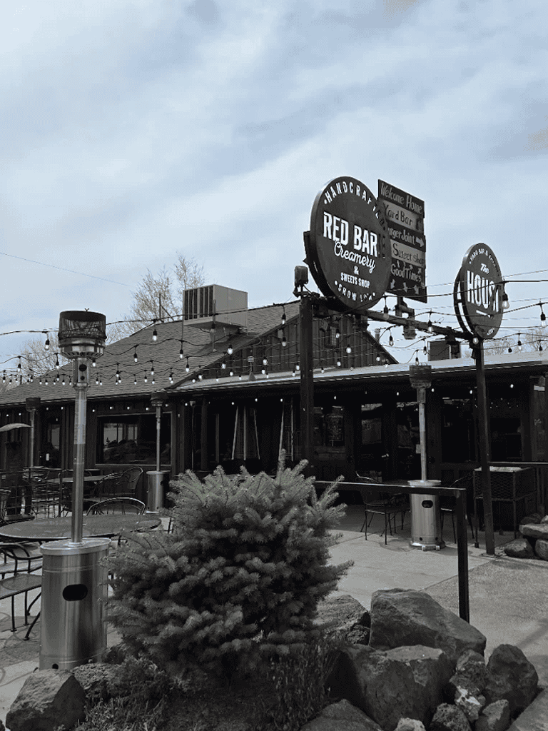 Outdoor patio of Red Bar Creamery restaurant with string lights and signage, inviting for dine-in and dessert lovers.