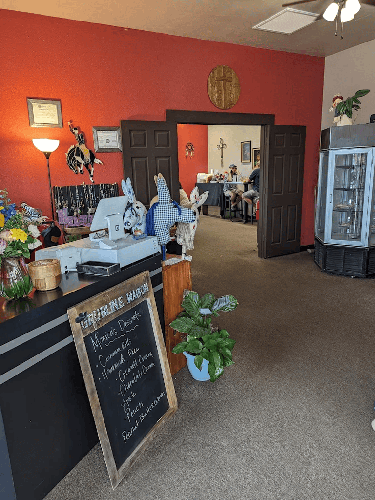 Colorful indoor bakery and café with festive decorations and dessert menu chalkboard.