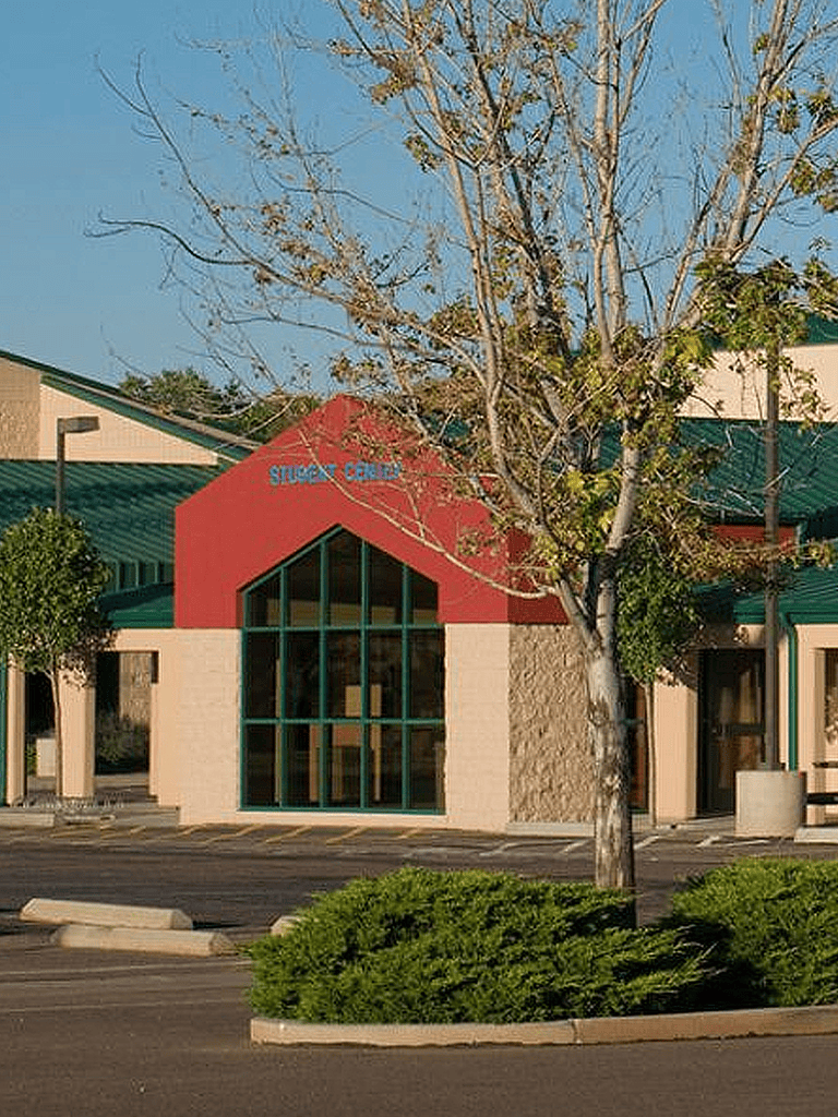 Modern educational facility with Student Center sign, large glass windows, and vibrant red and green accents.