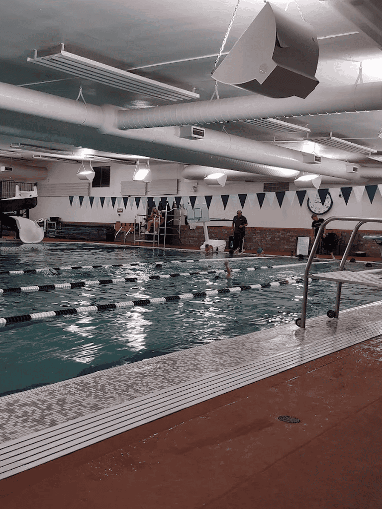 Indoor swimming pool at QuestForDirections fitness center, modern aquatic facility with lanes.