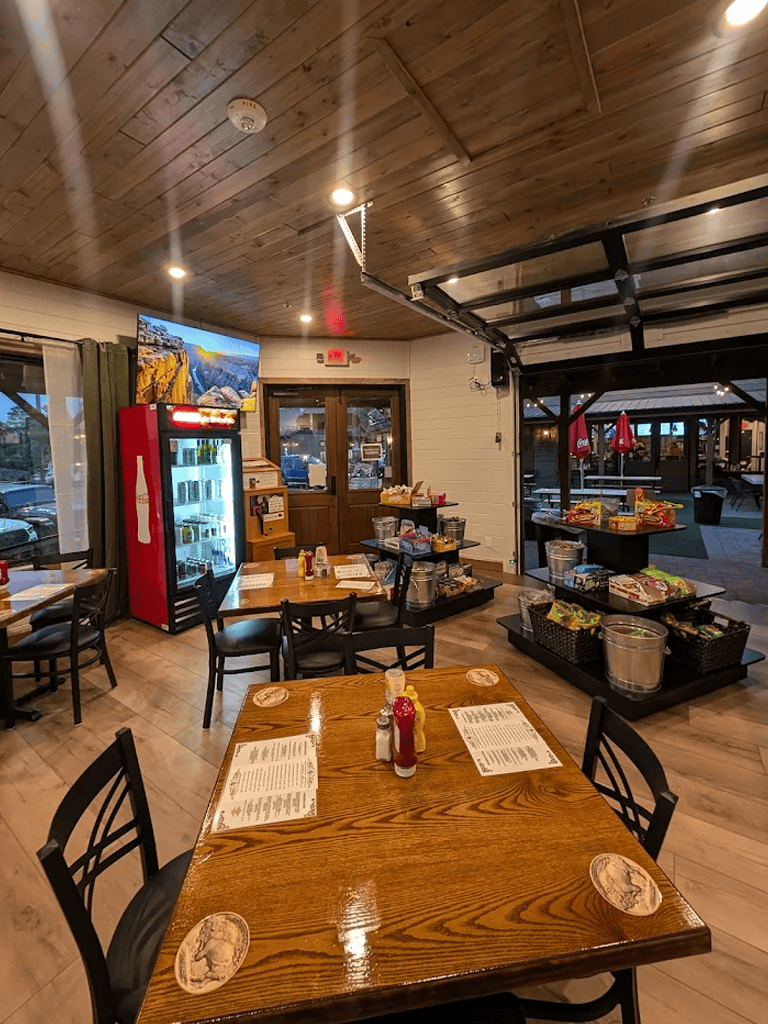 Warm cozy restaurant interior with wooden accents and a dessert display area.