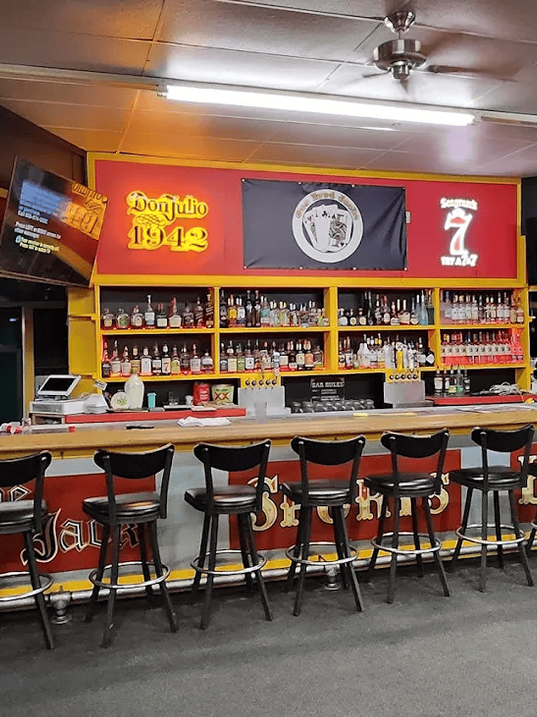 1. Well-stocked bar at Don Julio 1942 with premium liquors and vibrant decor.