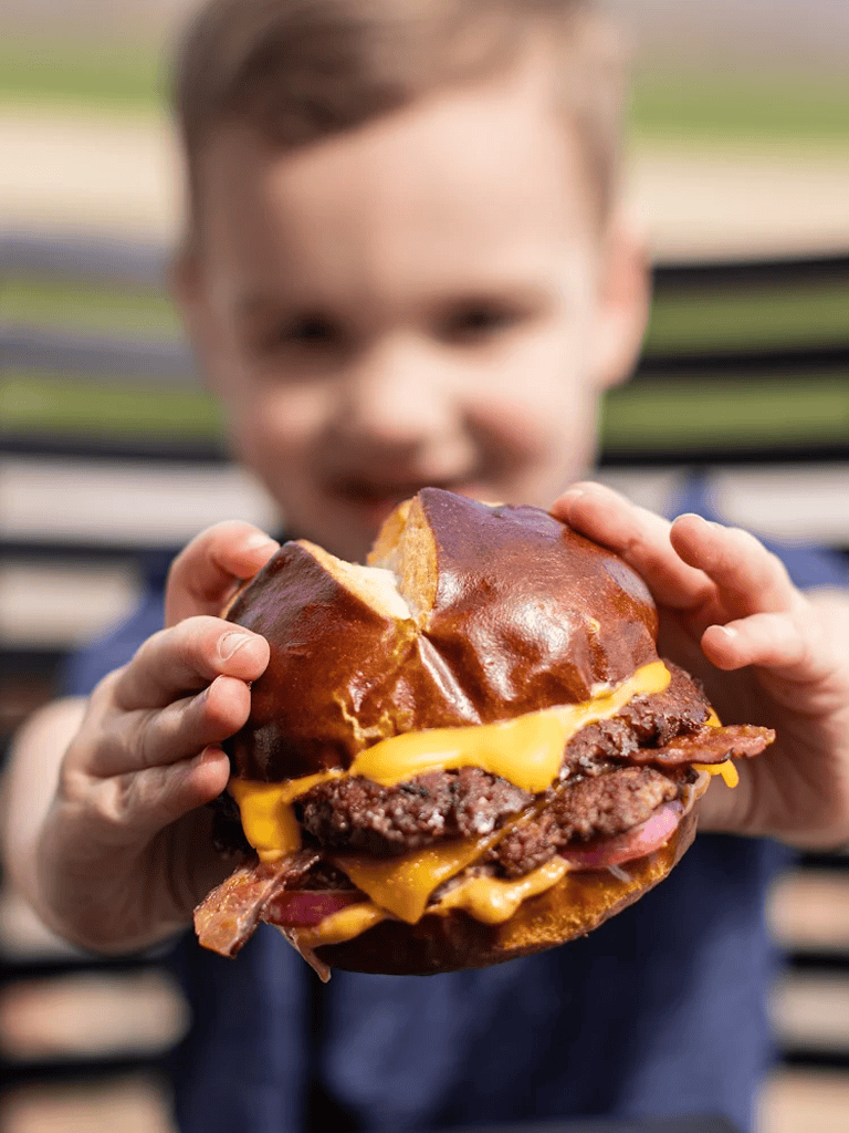 Delicious cheeseburger with beef patty, melted cheese, and bacon in a shiny bun.