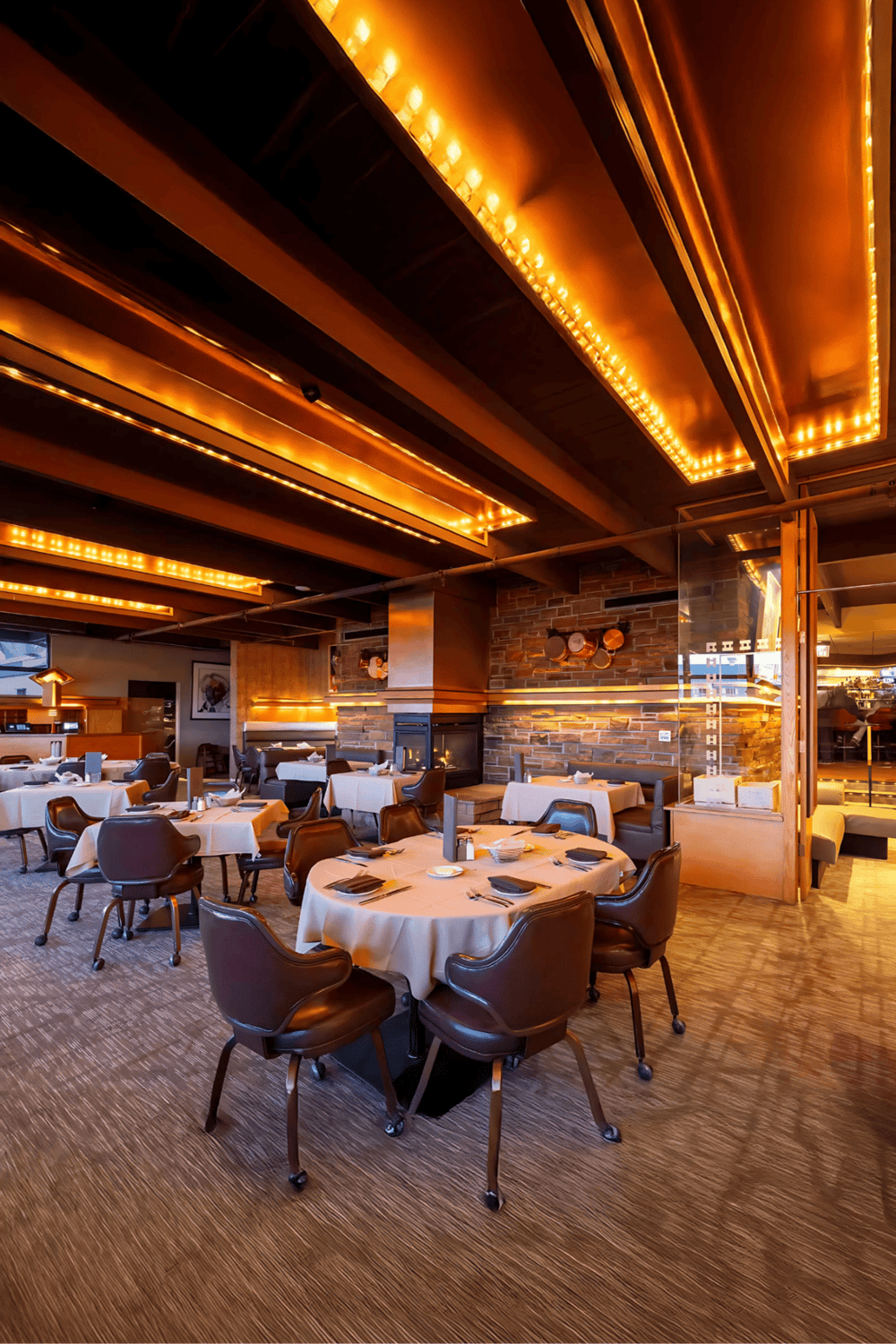 1. Warmly lit upscale restaurant interior with elegant dining tables and brick accents.