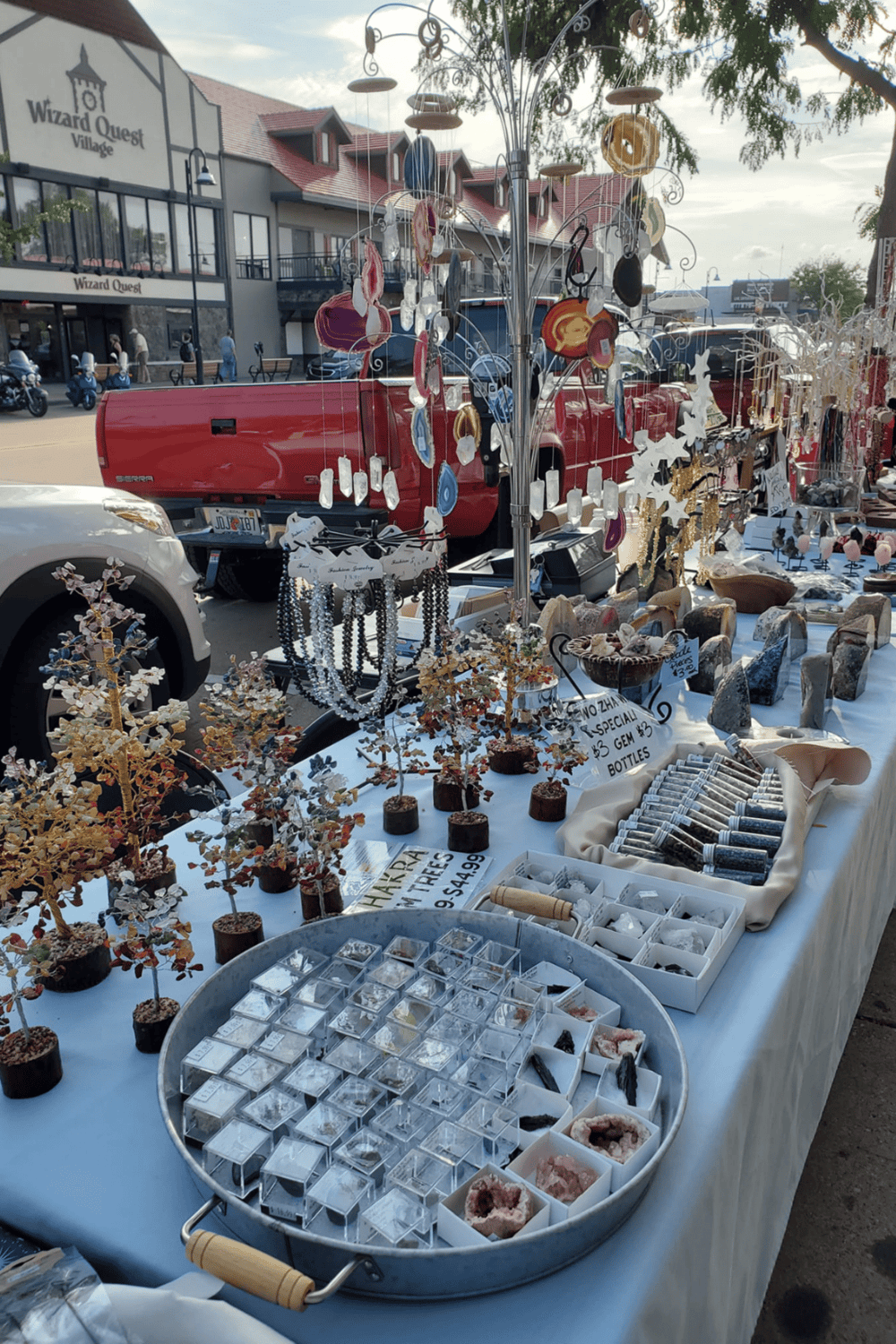 Handmade jewelry and decorative crafts at an outdoor market stall in Wizard Quest Village.