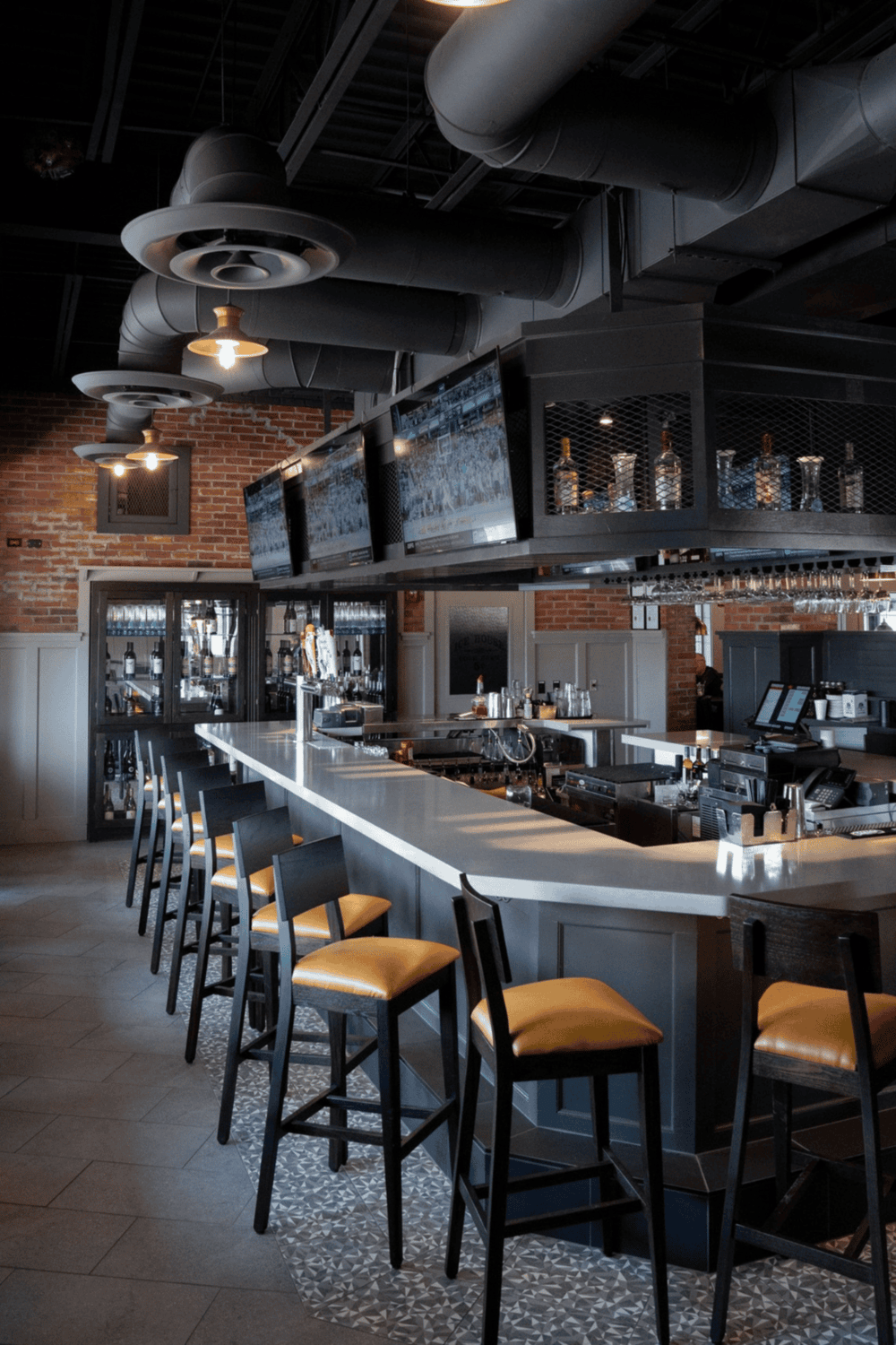 1. Modern bar interior with sleek design, TVs, and ambient lighting.