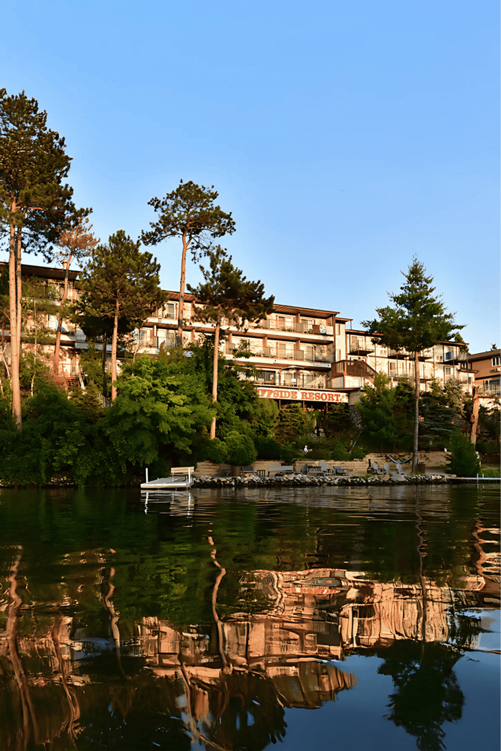 Waterfront resort with lakeside views and surrounding trees, perfect for outdoor relaxation and vacation getaways.