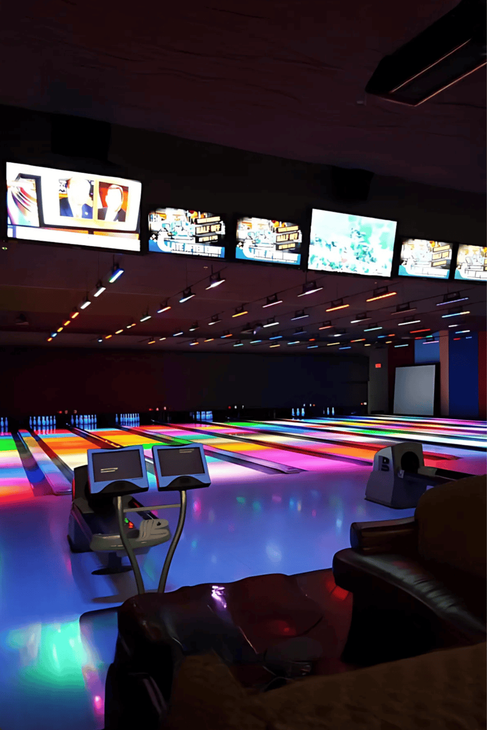 Brightly lit bowling alley with colorful lanes and digital scoring screens, perfect for entertainment and group activities.